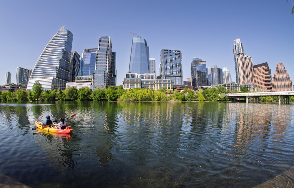 Kayakers paddle from shore on Lady Bird Lake in Austin Texas